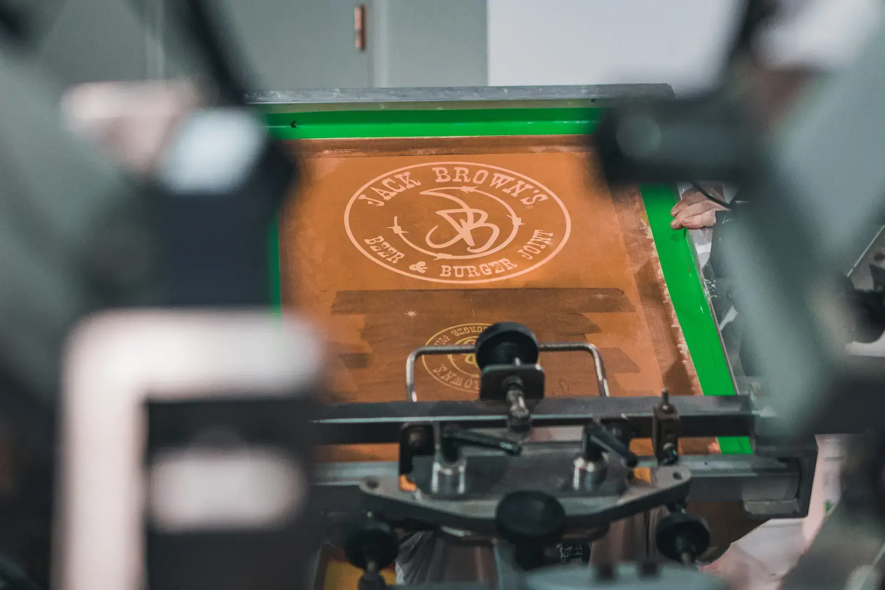 Burned screen on press for a Jack Brown's Beer and Burger Joint print at Alpine Apparel Co